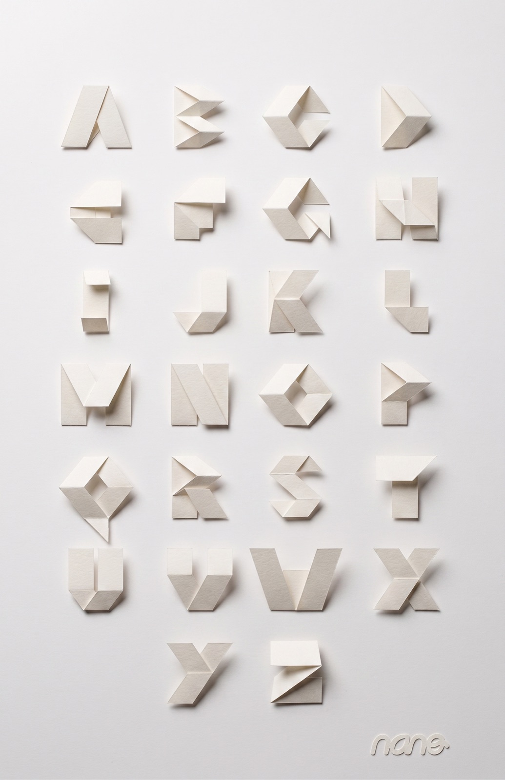 Las 26 letras del Alfabeto Modular, plegadas en papel blanco y fotografiadas con luz lateral