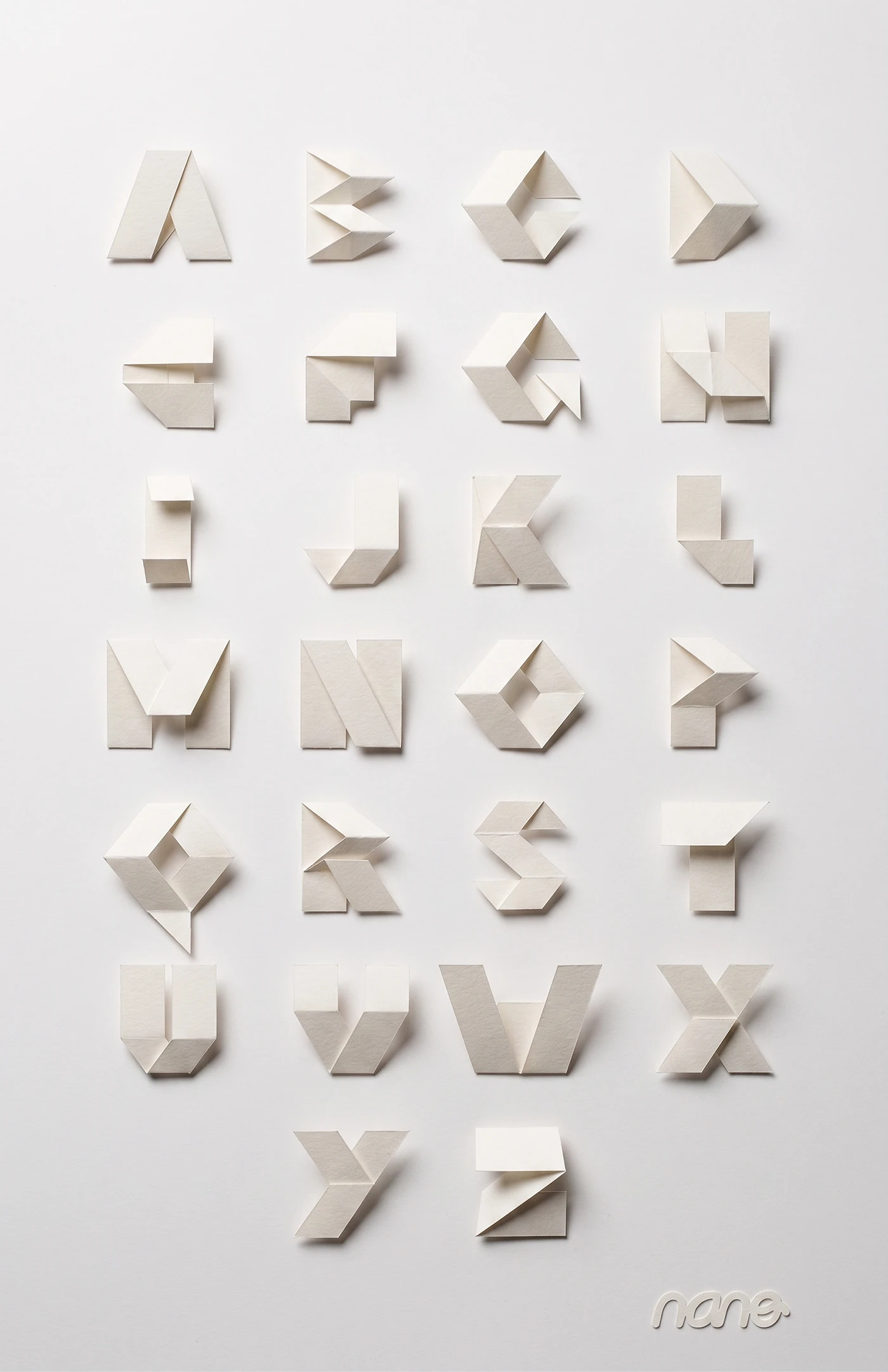 Las 26 letras del Alfabeto Modular, plegadas en papel blanco y fotografiadas con luz lateral