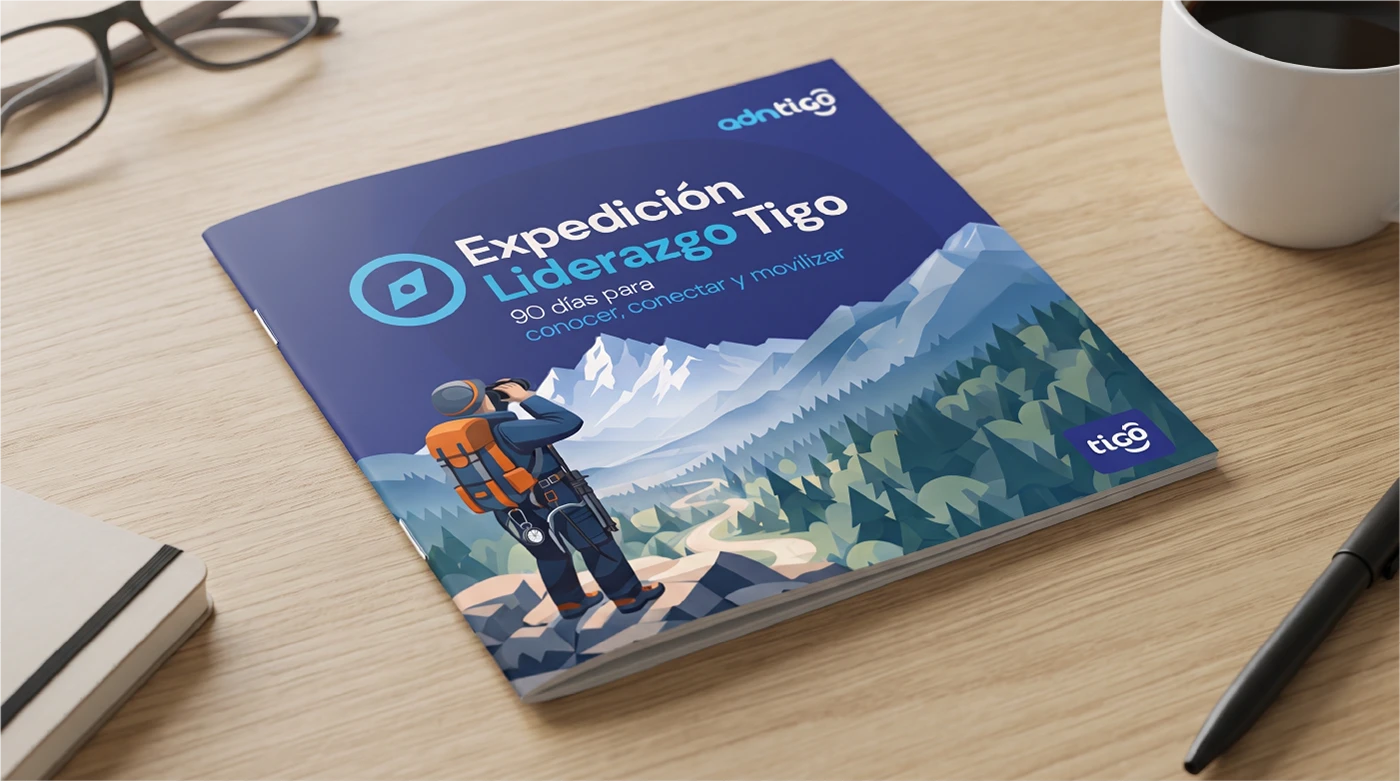 Portada de la cartilla Expedición de Liderazgo Tigo sobre un escritorio: un expedicionario mira las montañas con binoculares